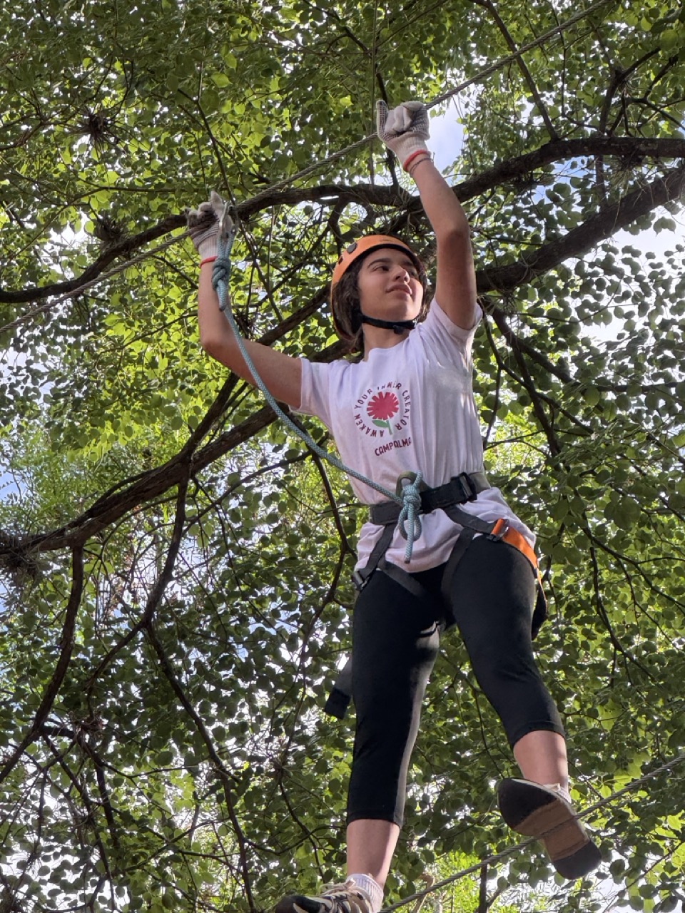 Participante de Campalma en una actividad de cuerdas altas entre árboles