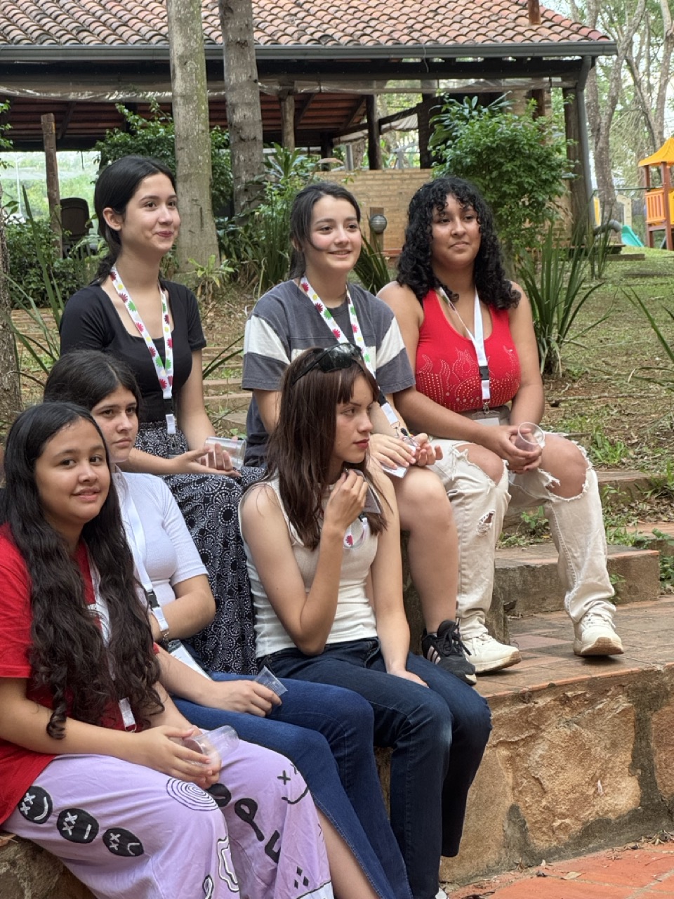 Participantes sentadas juntas en las gradas al aire libre